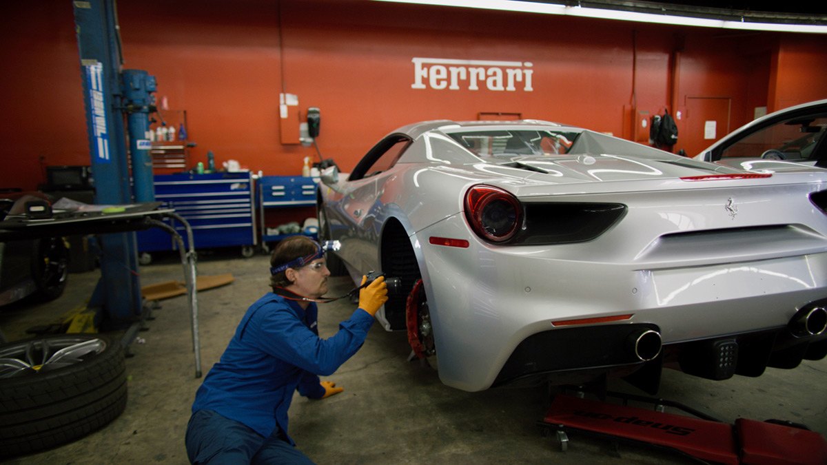 Mechanic working on a gray ferrari prior to diminished value appraisal