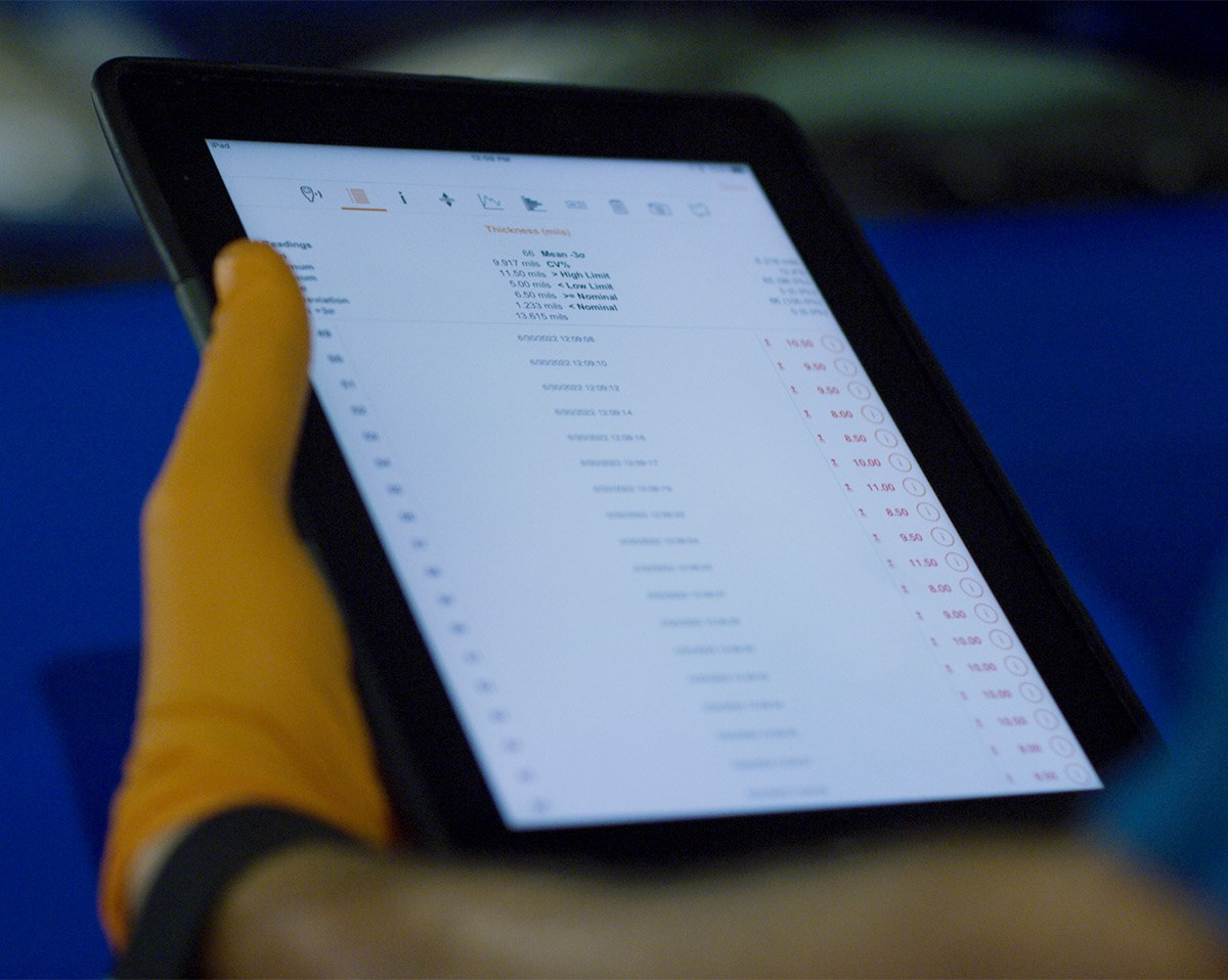 Close up of a hand holding an electronic tablet displaying a diminished value calculator